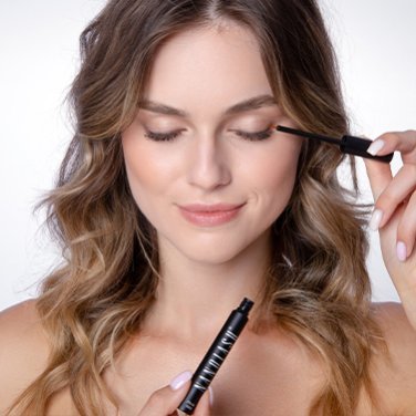 Model holding Nanolash eyelash serum in front of her face